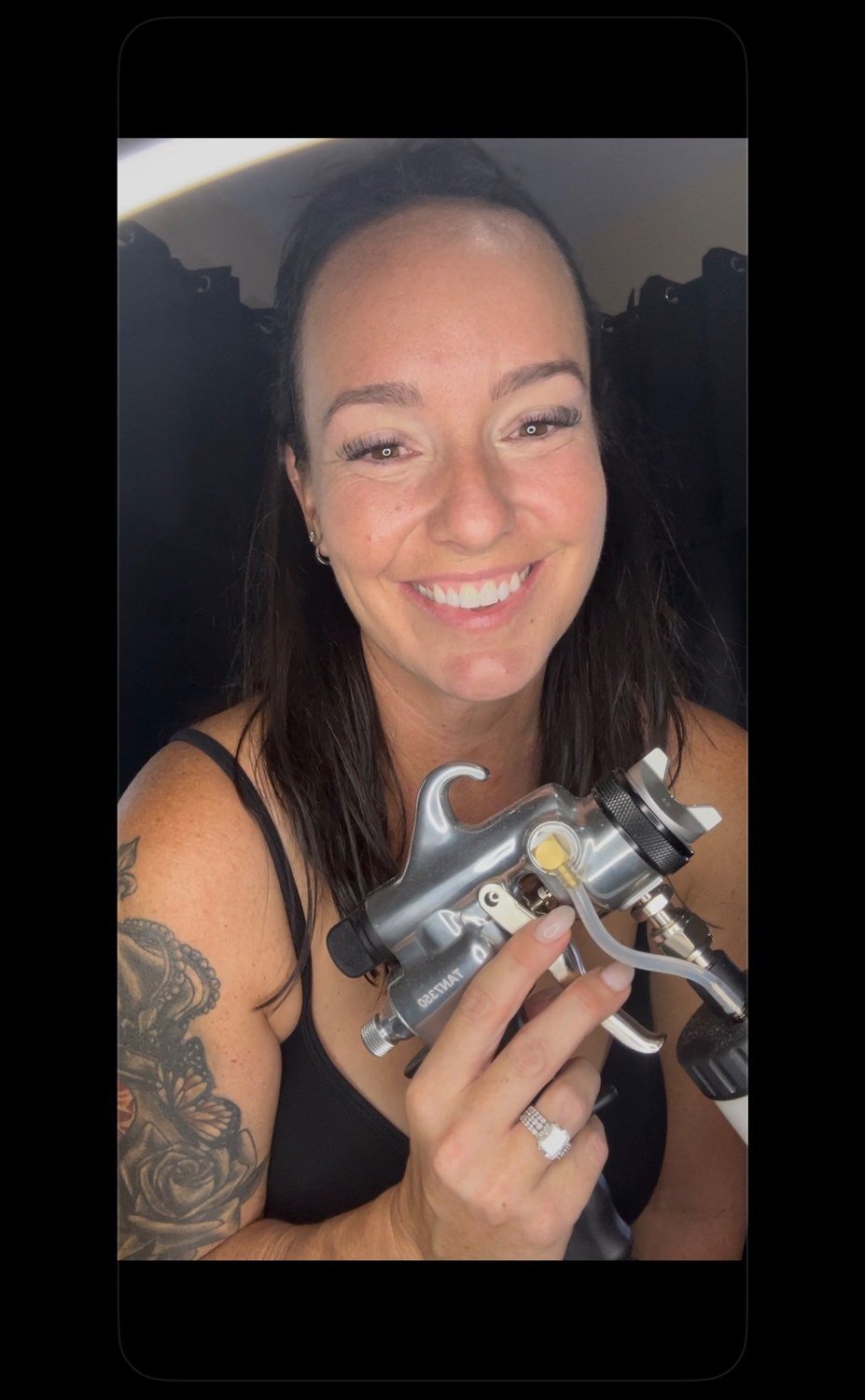 Sarah Castaneda holding a professional spray tan gun